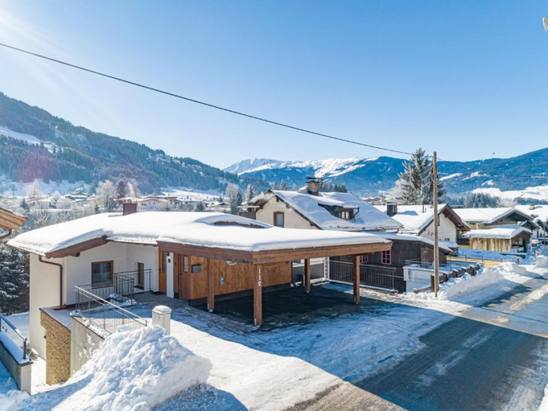 Besneeuwde chalet met bergen in Westendorf
