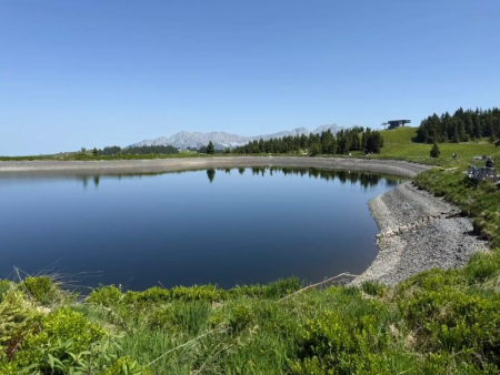 Grindpad langs een weidehek met weids uitzicht over het dal – Himmelsteig in het Alpinolino Entdeckerpark, Westendorf